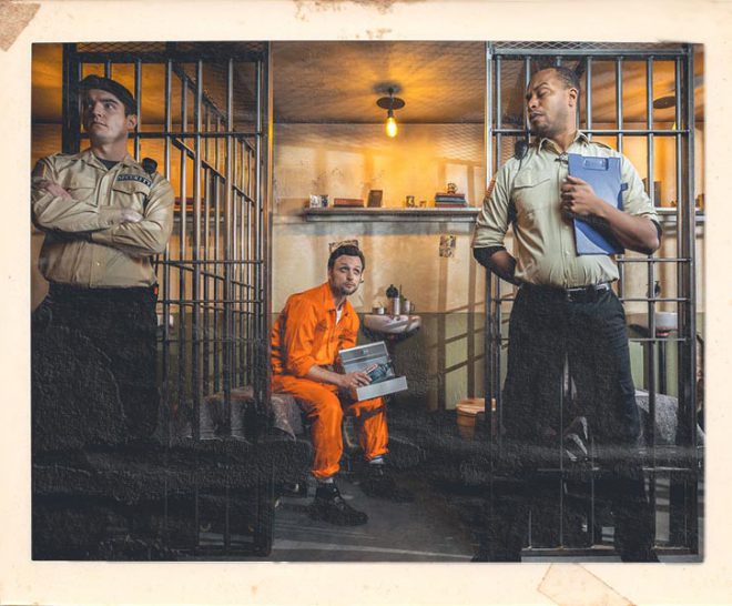 Inmate in cell at Alcotraz Liverpool - authentic prison-themed immersive cocktail bar experience.