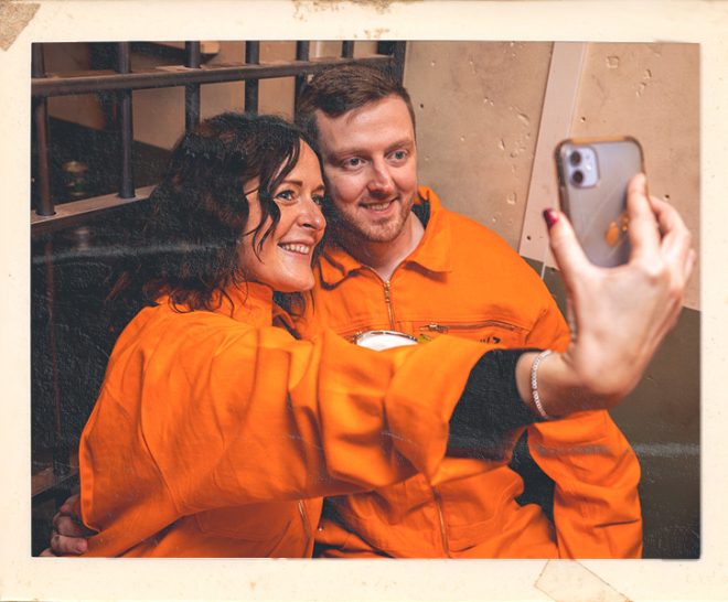 Couple taking selfie during date night at Alcotraz - memorable immersive prison bar experience for romantic evenings.
