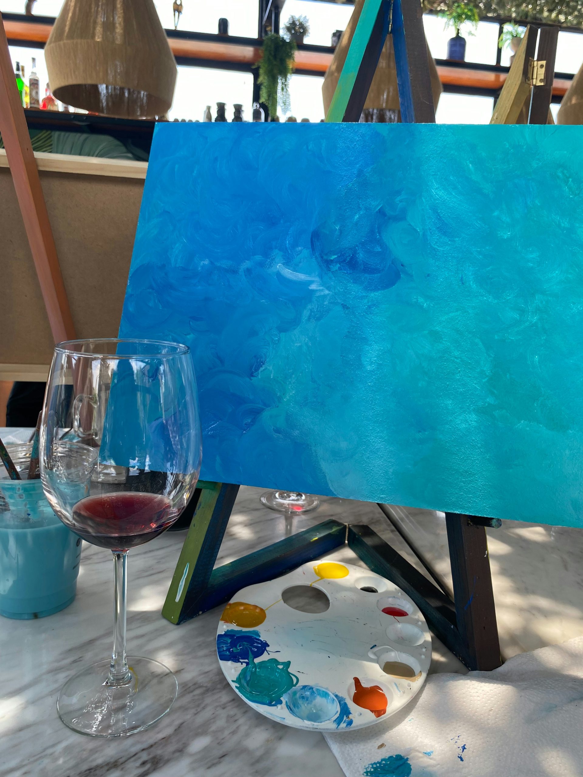 glass of wine next to painting